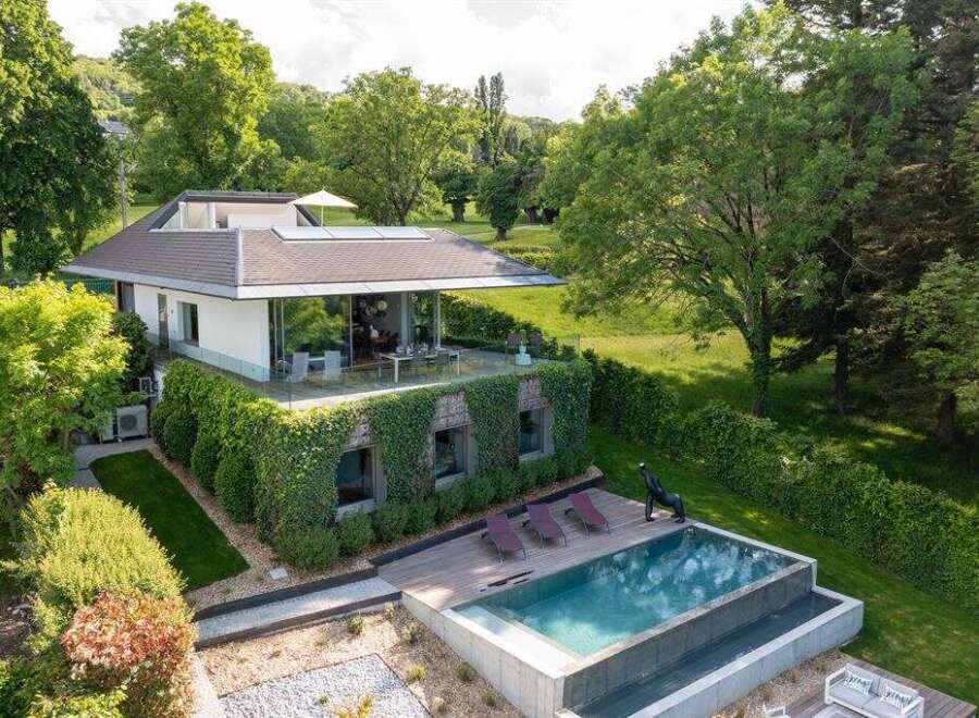 Experience modern luxury in this stunning home featuring a sleek design with expansive glass walls that seamlessly blend indoor and outdoor living.