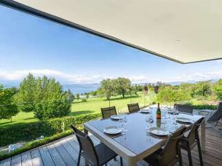 Enjoy breathtaking lake and golf course views from this stunning modern home's expansive deck.