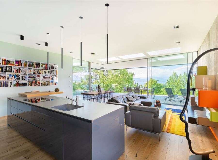 Experience modern living in this stunning open-concept home, featuring a sleek grey kitchen island and a spacious living area with breathtaking panoramic views.