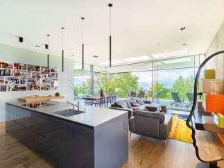 Experience modern living in this stunning open-concept home, featuring a sleek grey kitchen island and a spacious living area with breathtaking panoramic views.
