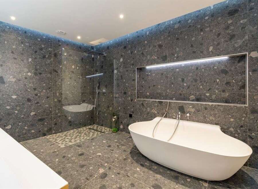 Experience modern luxury in this stunning bathroom, featuring a freestanding bathtub and a spacious walk-in shower.