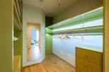 Step into this modern walk-in closet, featuring sleek, built-in shelving with integrated LED lighting for a sophisticated ambiance.