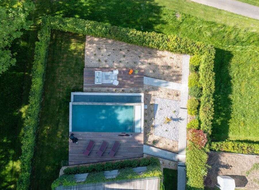 Experience luxury outdoor living with this stunning property featuring a sleek infinity pool and expansive wooden deck.
