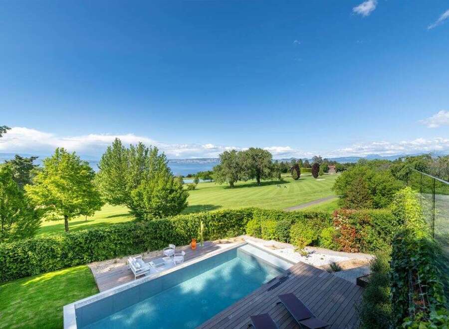 Experience luxury living with this stunning property featuring a modern infinity pool overlooking a picturesque golf course and serene lake.