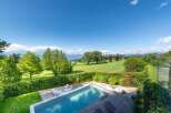 Experience luxury living with this stunning property featuring a modern infinity pool overlooking a picturesque golf course and serene lake.