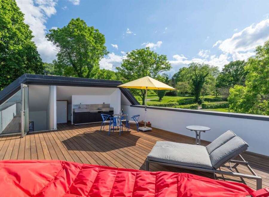 Enjoy outdoor living at its finest on this spacious rooftop deck, complete with a built-in outdoor kitchen and dining area.