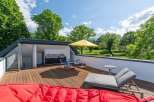 Enjoy outdoor living at its finest on this spacious rooftop deck, complete with a built-in outdoor kitchen and dining area.
