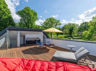Enjoy outdoor living at its finest on this spacious rooftop deck, complete with a built-in outdoor kitchen and dining area.