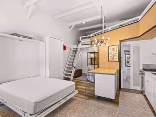 Discover this cleverly designed studio apartment featuring a space-saving Murphy bed that maximizes living area.