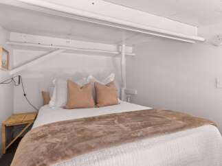 This cozy bedroom features a comfortable queen-size bed adorned with plush pillows and a soft throw blanket, perfect for relaxation.