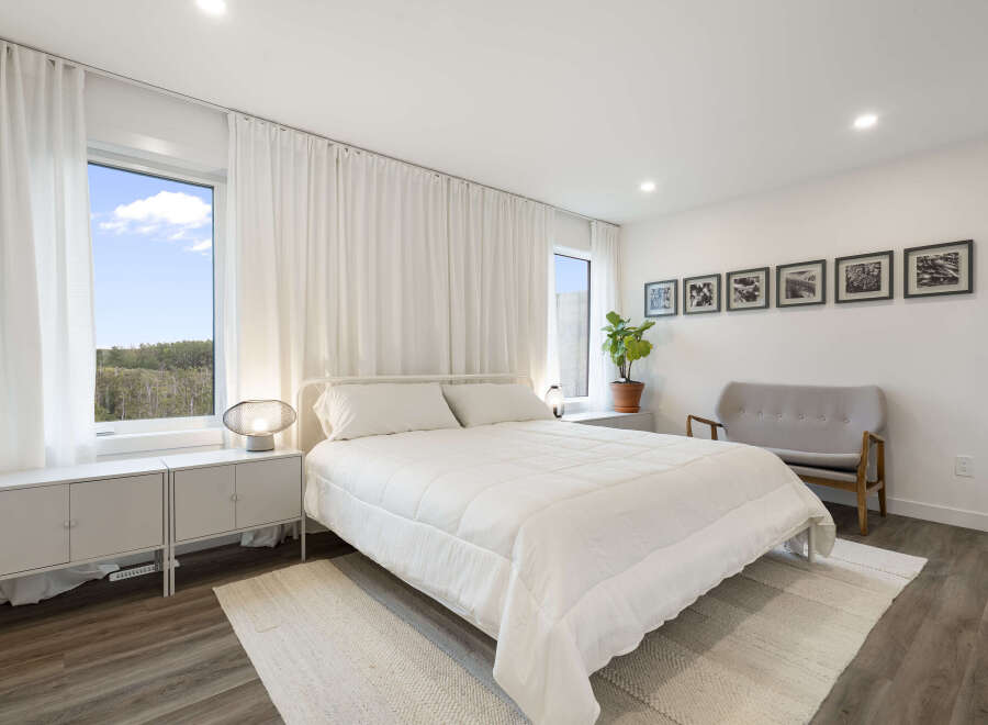 Experience modern comfort in this serene bedroom, featuring a plush white duvet and a minimalist aesthetic.