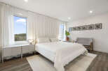 Experience modern comfort in this serene bedroom, featuring a plush white duvet and a minimalist aesthetic.