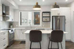 Experience modern living in this stunning kitchen, featuring sleek white cabinetry, a spacious island with bar seating, and top-of-the-line stainless steel appliances.