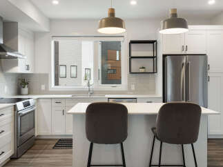 Experience modern living in this stunning kitchen, featuring sleek white cabinetry, a spacious island with bar seating, and top-of-the-line stainless steel appliances.