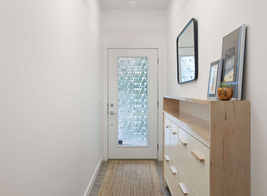 Step into this inviting entryway, featuring a stylish console table with ample storage and a decorative mirror.