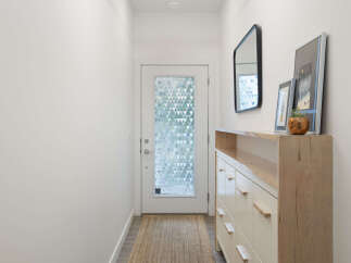 Step into this inviting entryway, featuring a stylish console table with ample storage and a decorative mirror.