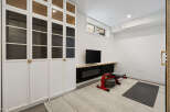 This modern home gym features a sleek white built-in cabinet with glass doors, perfect for storing workout gear.