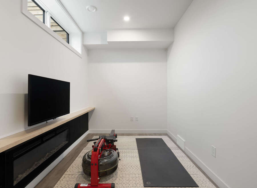 Transform this versatile space into your personal home gym, complete with a rowing machine and yoga mat.