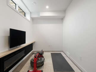 Transform this versatile space into your personal home gym, complete with a rowing machine and yoga mat.