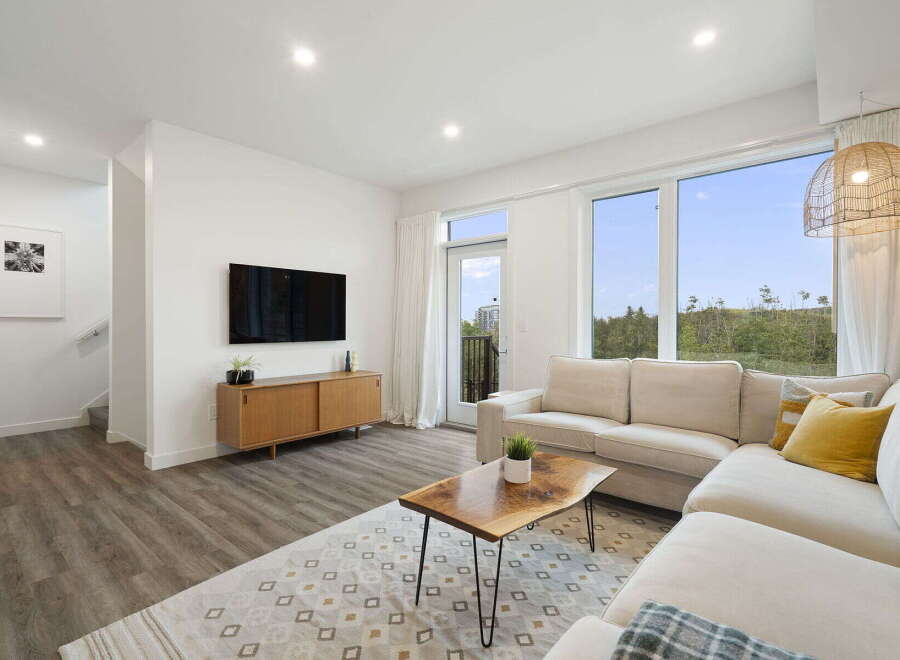 Experience modern living in this bright and airy living room, featuring a spacious sectional sofa perfect for relaxation and entertaining.