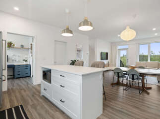 Discover modern living in this open-concept space, featuring a sleek kitchen island with integrated microwave and ample storage.