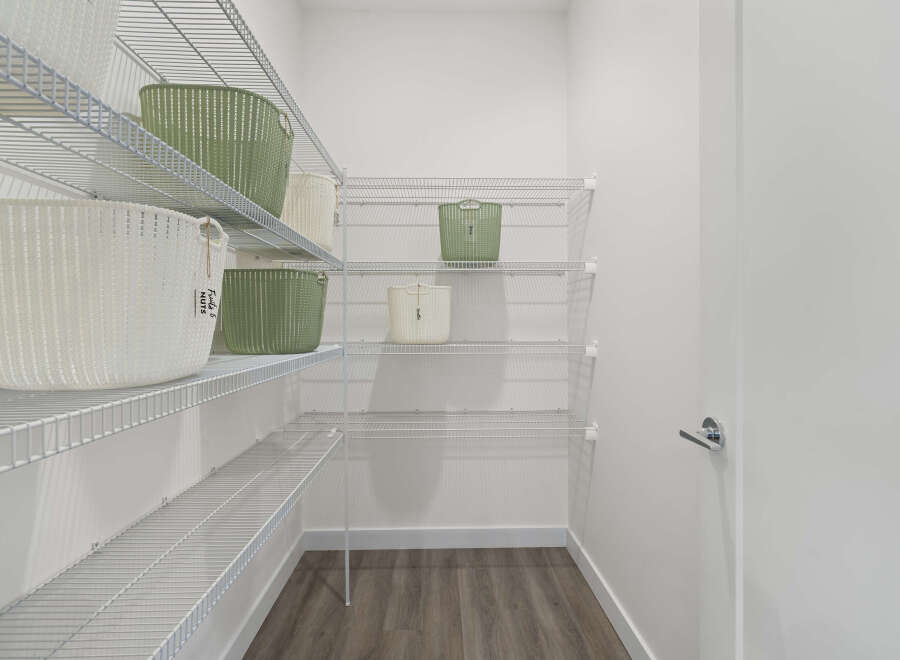 Discover ample storage in this spacious walk-in closet, featuring multiple wire shelves perfect for organizing your belongings.