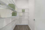 Discover ample storage in this spacious walk-in closet, featuring multiple wire shelves perfect for organizing your belongings.