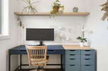 This home office features a modern desk setup with a sleek dark blue desk and a complementary grey drawer unit.