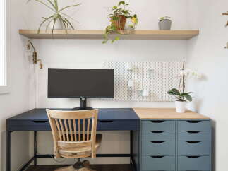 This home office features a modern desk setup with a sleek dark blue desk and a complementary grey drawer unit.