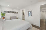 This bright and airy bedroom features a comfortable queen-size bed with crisp white linens, perfect for relaxation.