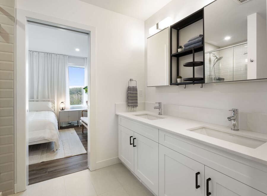 Experience modern luxury in this stunning bathroom featuring a dual vanity with sleek white countertops and chrome fixtures.