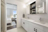 Experience modern luxury in this stunning bathroom featuring a dual vanity with sleek white countertops and chrome fixtures.