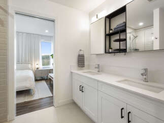 Experience modern luxury in this stunning bathroom featuring a dual vanity with sleek white countertops and chrome fixtures.