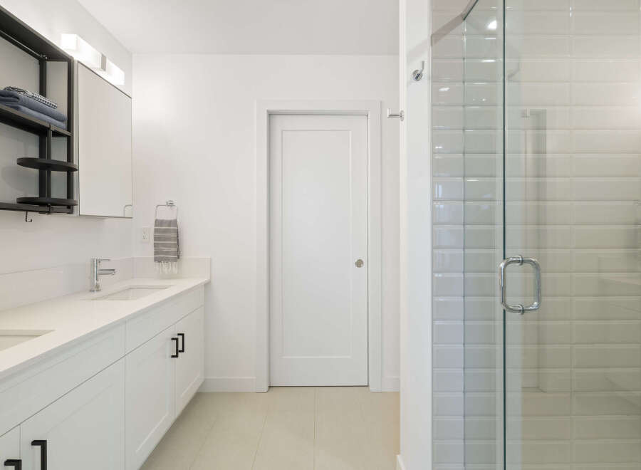 Experience modern luxury in this stunning bathroom featuring a sleek vanity with dual sinks and ample storage.