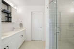Experience modern luxury in this stunning bathroom featuring a sleek vanity with dual sinks and ample storage.