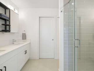 Experience modern luxury in this stunning bathroom featuring a sleek vanity with dual sinks and ample storage.