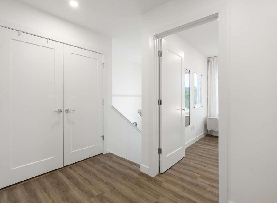 Step into this bright and airy hallway featuring a modern staircase and sleek white doors.