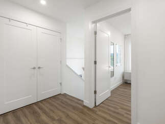 Step into this bright and airy hallway featuring a modern staircase and sleek white doors.