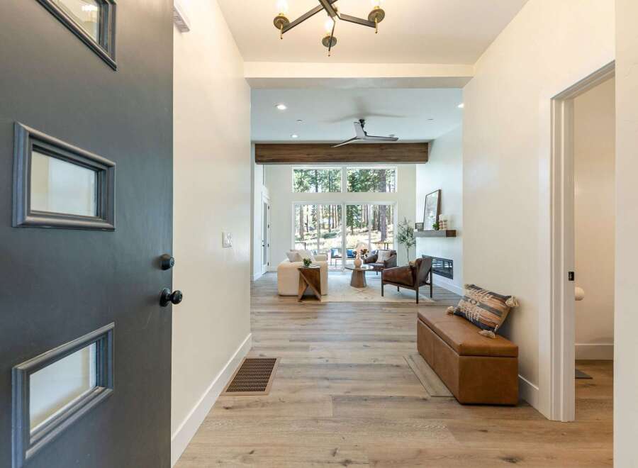 Step into this inviting entryway, featuring a modern dark gray door with unique geometric windows.