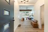 Step into this inviting entryway, featuring a modern dark gray door with unique geometric windows.