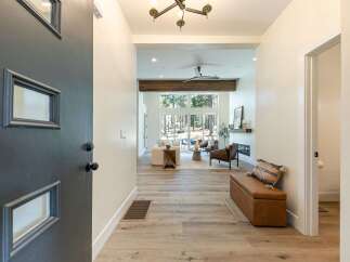 Step into this inviting entryway, featuring a modern dark gray door with unique geometric windows.