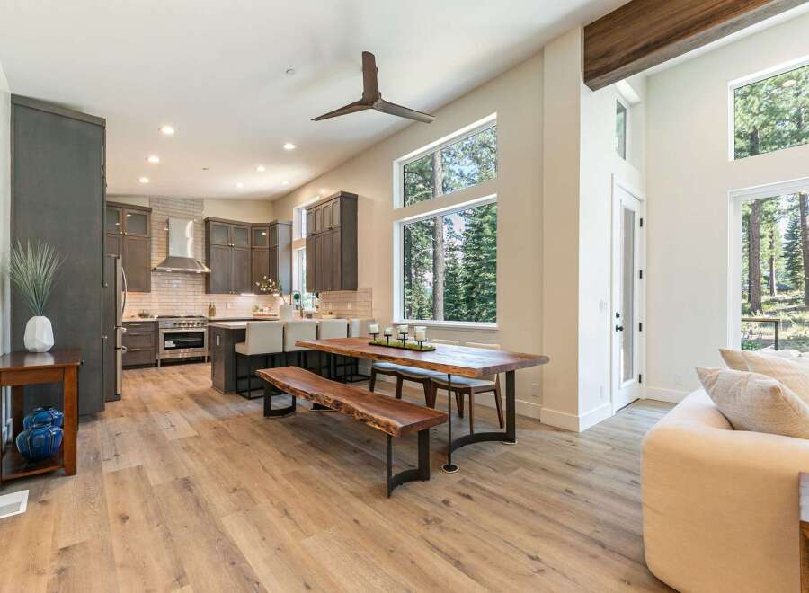 Experience modern living in this spacious open-concept home featuring a gourmet kitchen with dark cabinetry and a sleek stainless steel range hood.