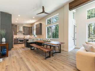 Experience modern living in this spacious open-concept home featuring a gourmet kitchen with dark cabinetry and a sleek stainless steel range hood.