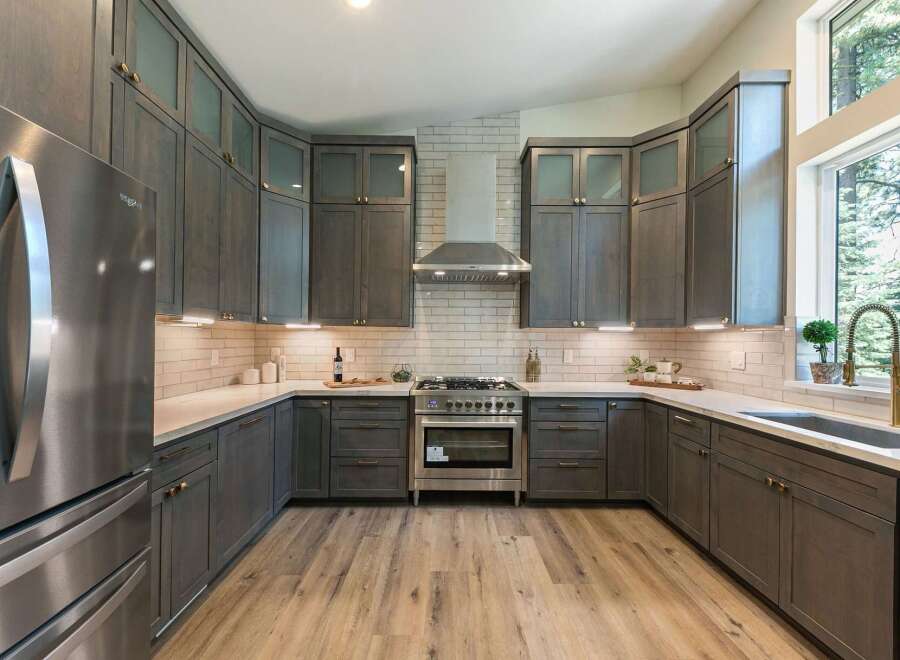 Experience modern luxury in this stunning kitchen, featuring sleek, dark gray cabinetry complemented by a classic white subway tile backsplash.