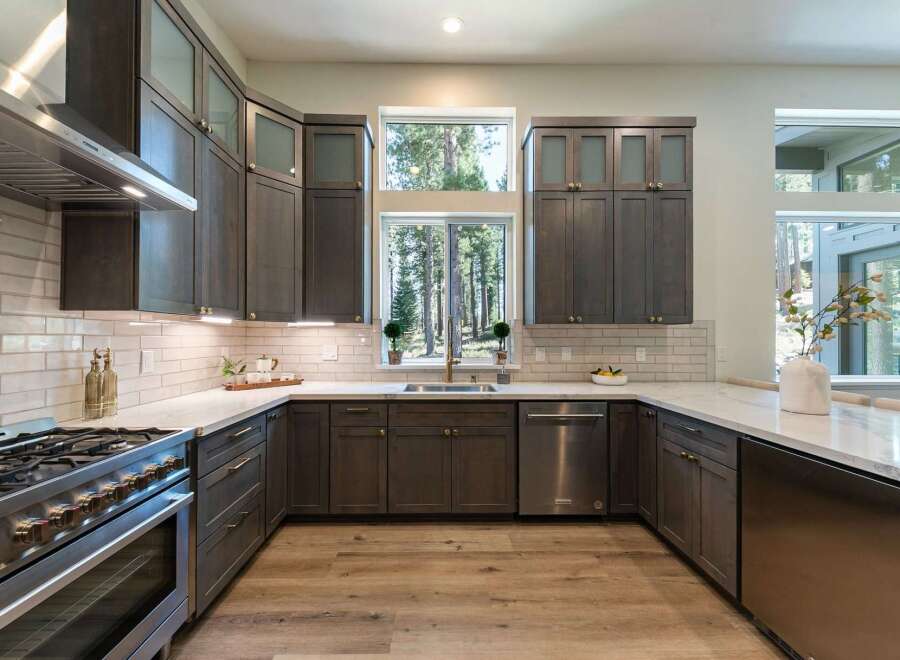Experience modern living in this stunning kitchen featuring dark wood cabinetry and sleek stainless steel appliances.