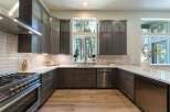 Experience modern living in this stunning kitchen featuring dark wood cabinetry and sleek stainless steel appliances.