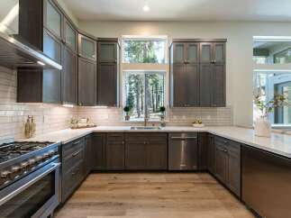 Experience modern living in this stunning kitchen featuring dark wood cabinetry and sleek stainless steel appliances.
