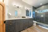 Experience modern luxury in this stunning bathroom featuring a spacious double vanity with elegant marble countertops and gold hardware.