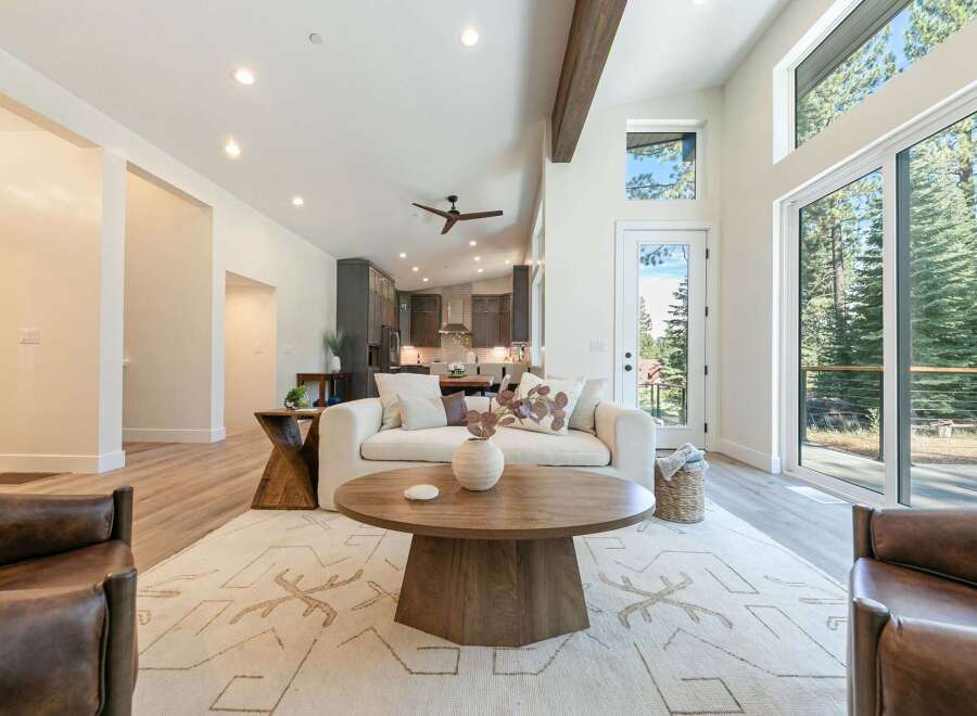 Experience modern living in this spacious great room, featuring soaring vaulted ceilings and a dramatic wooden beam.