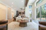 Experience modern living in this spacious great room, featuring soaring vaulted ceilings and a dramatic wooden beam.